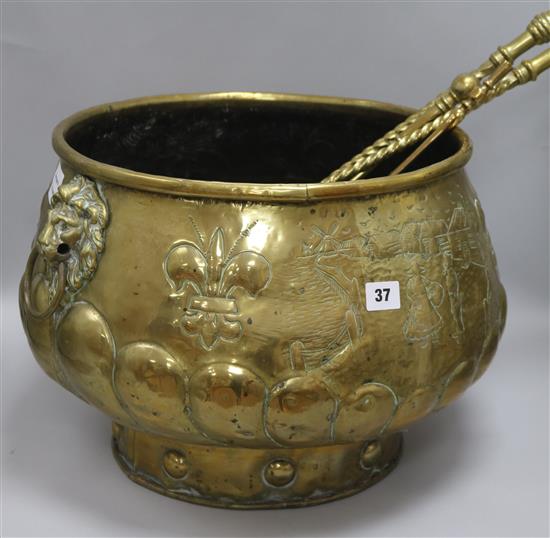 A 19th century embossed brass half lobed compressed drum jardinière, with lion mask ring handles and sundry fire brasses